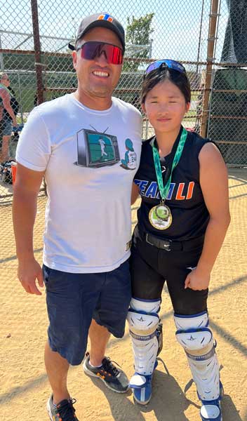 New York Rise founder Jeff Ahn proudly stands by as his daughter, Josie Ahn, accepts a youth softball tournament MVP award last July.